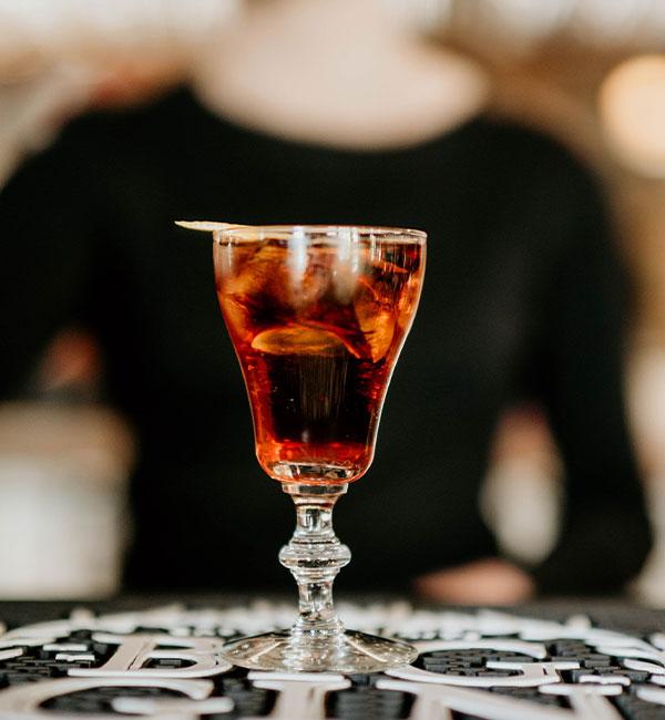 A cocktail with ice and garnish, served in a stemmed glass at Leku Ona Restaurant Boise Idaho.