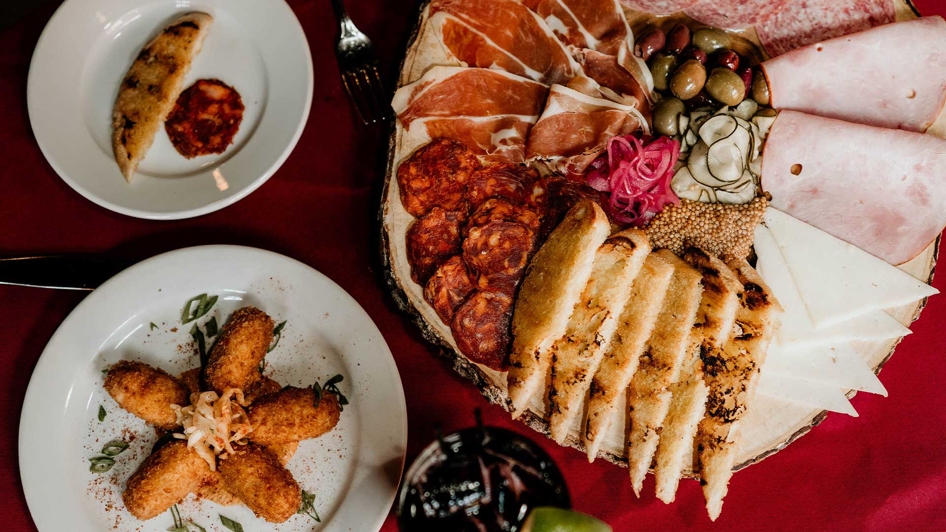 Charcuterie board at Leku Ona Restaurant Boise Idaho, served with croquettes, cheese, and bread.